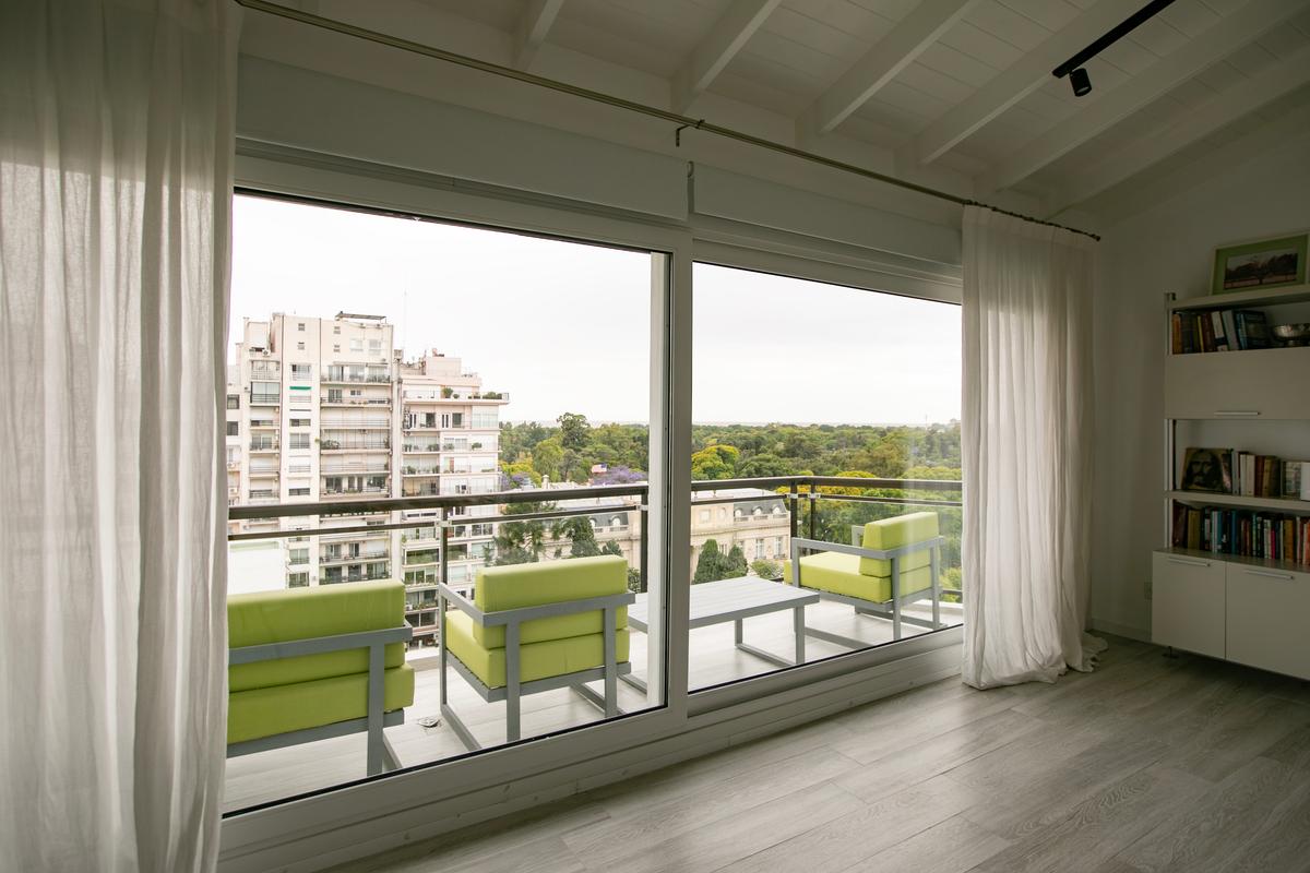 Varanda moderna com poltronas verdes e vista urbana — projeto Obra Segui M A, por Arq. Lourdes Yarade Saravia, em Buenos Aires